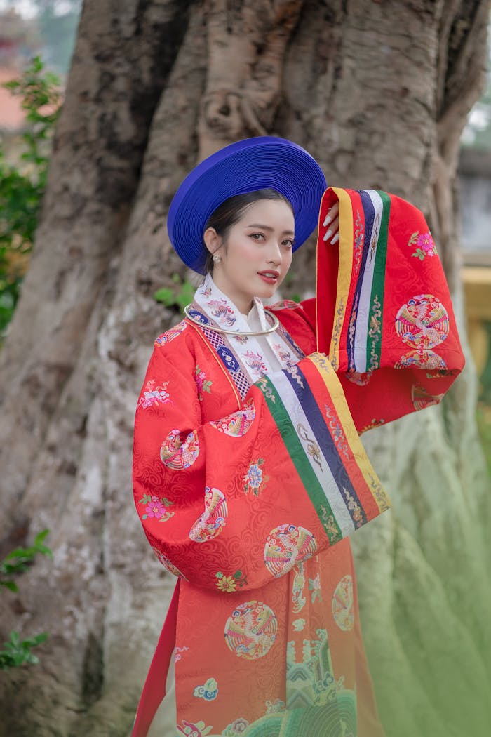 Portrait of a woman in colorful traditional ethnic outfit posing gracefully outdoors.