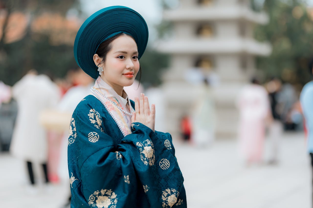 Portrait of a woman in traditional Vietnamese dress outdoors at day, showcasing cultural elegance.
